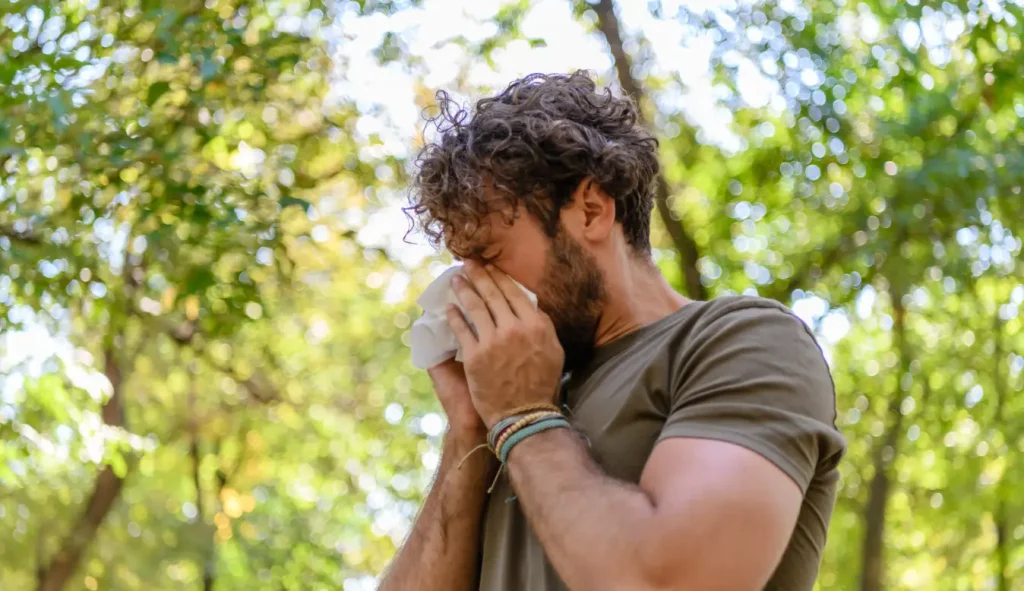 hay fever and alcohol. A man blowing his nose